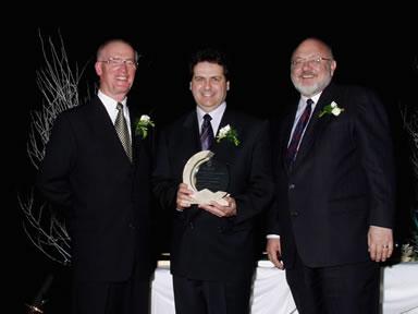 Hugh Krentz et Peter Clark présentent le Prix de dévouement décerné aux entreprises à André Lagace 
