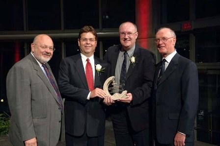 Peter Clark et Hugh Krentz présentent le Prix de dévouement décerné aux entreprises à Egan Cobbold et Roland Rotter