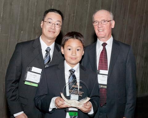Photo de Patrick Wong et Nathan Wong, fils et petit-fils de George S. K. Wong, acceptent en son nom le Prix de leadership 2010 du CCN des mains de Hugh Krentz, président du Conseil du CCN.