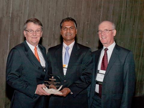 Photo de Jeet Tulshi et Michael Newlands, au nom de la CSA, acceptent le Prix de dévouement 2010 décerné aux entreprises des mains de Hugh Krentz, président du Conseil du CCN.
